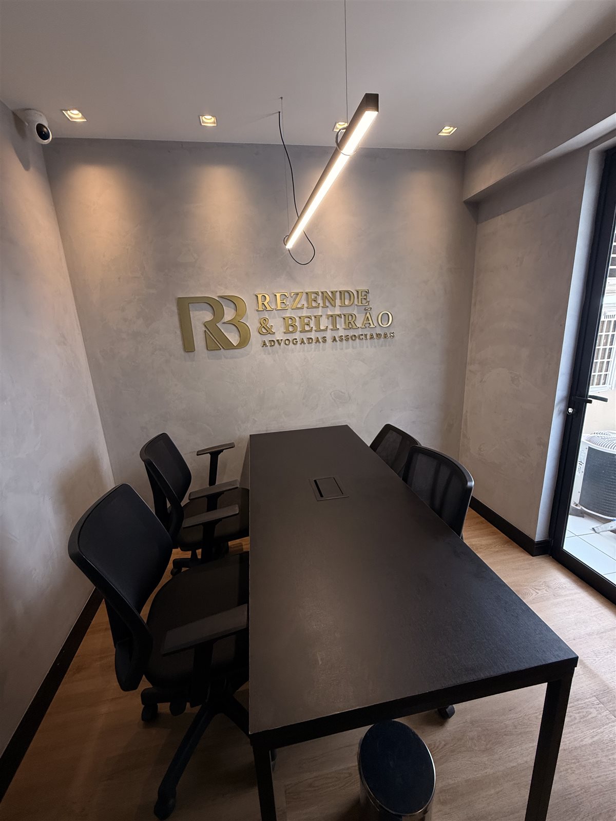 Sala de reunião com o logotipo do Rezende & Beltrão Advocacia