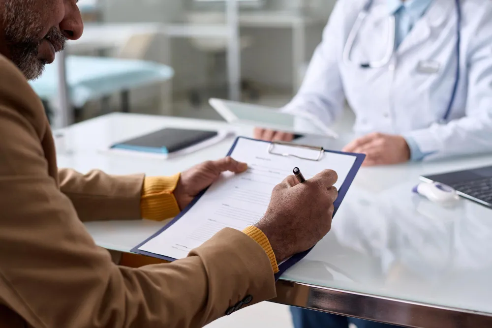 Paciente assina formulário em consulta médica para auxílio-acidente perícia.