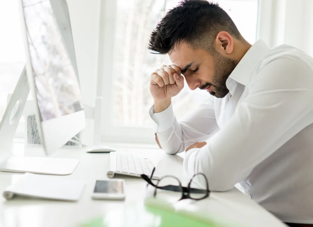 Homem estressado no escritório, pensando se auxílio-acidente precisa de advogado.